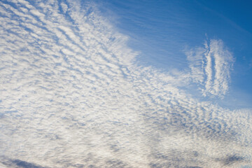 Spindrift white clouds on blue sky