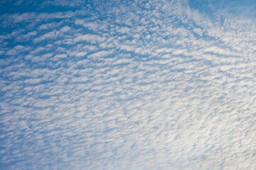 Spindrift white clouds on blue sky