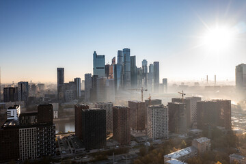 a panoramic view of the city business skyscrapers in the morning fog at sunrise filmed from a drone 
