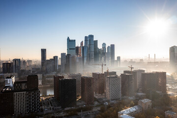 Fototapeta premium a panoramic view of the city business skyscrapers in the morning fog at sunrise filmed from a drone 