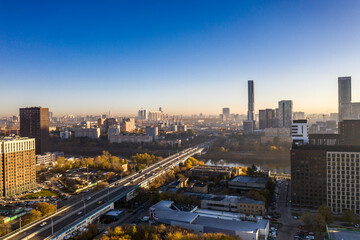 Naklejka na ściany i meble a panoramic view of the city business skyscrapers in the morning fog at sunrise filmed from a drone 