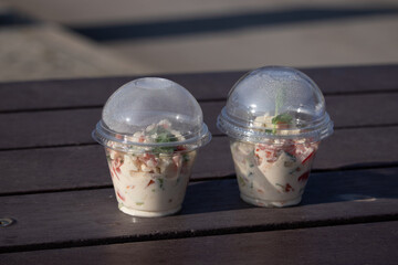 salad with tomatoes and cucumber in disposable food containers street food