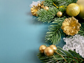 Christmas decorations, pine tree leaves, golden balls, snowflakes, golden berries on blue background