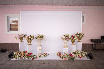 Fototapeta na wymiar White photo zone with flowers. event decor.