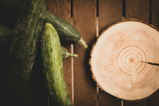Image Of Wooden Round Disc And Fresh Cucumbers.
