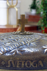 Cross on the baptismal font in the parish church of St. Paul in Retkovec, Zagreb, Croatia