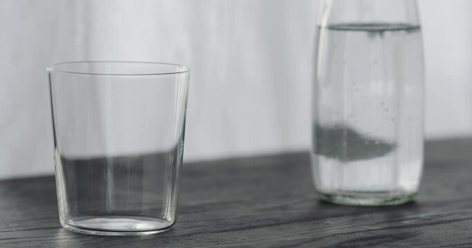Slow motion pour espresso in tumbler glass on black aok table