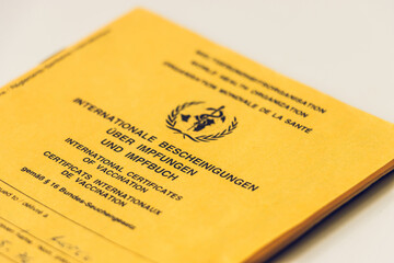 Cover sheet from the vaccination certificate. Yellow card with evidence of necessary WHO vaccinations. Internationally recognized health passport of the World Health Organization