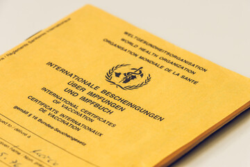 View of the vaccination certificate. Yellow card with evidence of necessary WHO vaccinations. Internationally recognized health passport of the World Health Organization