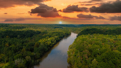 Fototapeta na wymiar a stunning aerial panoramic shot of the Chattahoochee river surrounded by lush green and autumn colored trees with powerful clouds at Cochran Shoals Trail in Marietta USA 