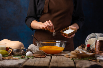 The chef prepares pumpkin filling for the classic American pumpkin pie. Ingredients, decor. Close-up. Traditional cake for Halloween, Thanksgiving, Christmas, New Years, family gatherings..