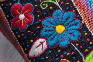 Fototapeta na wymiar Peruvian crafts: Embroidered flower ornaments on a handmade fabric