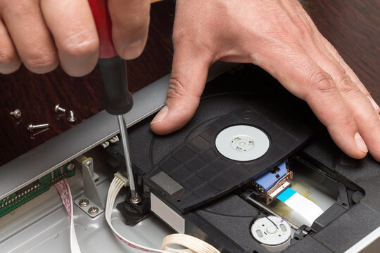 A Man Holds A Screwdriver And Unscrews The Mechanism Of The DVD Player For Repair, Adobe RGB Color Space