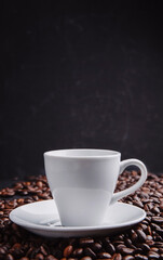 Cup with roasted coffee beans. Close up shot. cups on  table with scattered coffee beans. Soft focus.