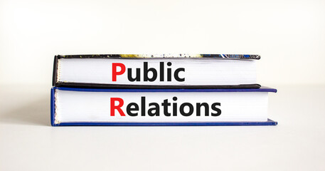 PR public relations symbol. Concept words 'PR, public relations' on books on white table, white background, copy space. Business and PR public relations concept.
