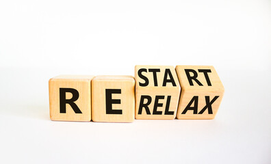 Relax and restart symbol. Businessman turned cubes and changed the word 'relax' to 'restart'. Beautiful white table, white background. Business, relax and restart concept. Copy space.