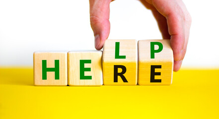 Help is here symbol. Businessman turns cubes and changes the word help to here. Beautiful white background, copy space. Business, motivational and help is here concept.