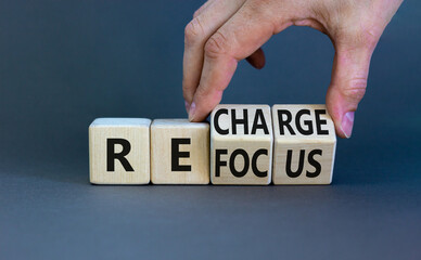 Refocus and recharge symbol. Businessman turns cubes and changes the word 'refocus' to 'recharge'....