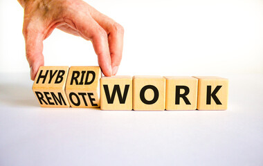Hybrid or remote work symbol. Businessman turns cubes and changes words 'remote work' to 'hybrid work'. Beautiful white background. Business, hybrid or remote working concept, copy space. - obrazy, fototapety, plakaty