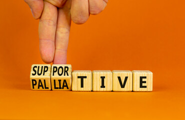 Palliative or supportive therapy symbol. Doctor turns cubes, changes words palliative to supportive. Beautiful orange background, copy space. Medical, palliative or supportive therapy concept.