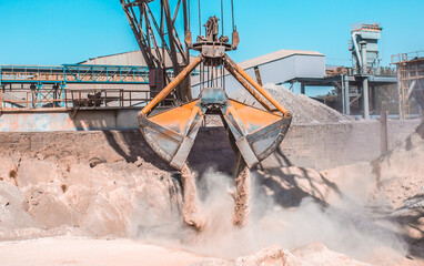 Modern technology of the bucket moves gravel, work at a cement plant. Technological work on the...