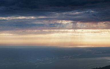 Thunderclouds over the sea at sunset disappearing into the horizon