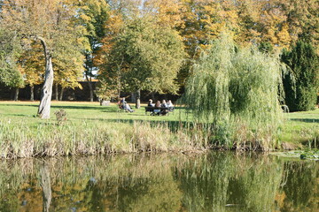 Grupa ludzi na ławce. Stoczek Klasztorny. Staw w parku. Polska - Mazury - Warmia. © Rafa