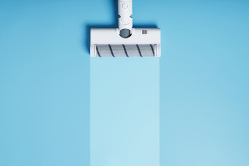 White vacuum cleaner brush on a blue background, top view. With a clean stripe