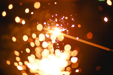 Sparks and sparklers in the dark. Festive fire texture, background for new year and Christmas.
