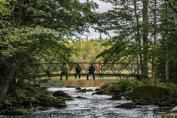 Fototapeta na wymiar 3 people on a bridge in the fall