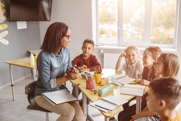 Happy teacher having a lesson with kids in the classroom