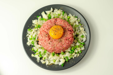 Beef steak tartare with raw egg yolk and onion with chive