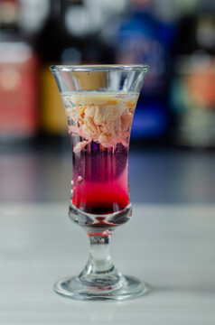 Interesting drink shot based on cream, liqueur and grenadine called Brain Hemorrhage prepared for Halloween party
