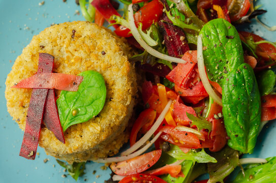 Smoked haddock fishcake with melting cheddar sauce and mixed salad on the blue plate