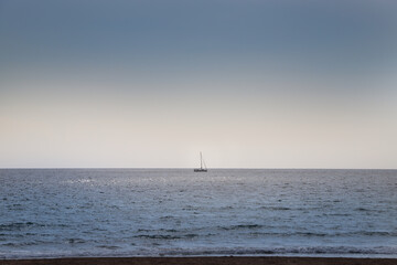 Sailing Boat at the Horizon in the Ocean