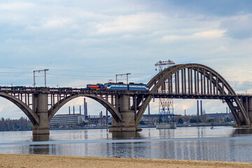 Train rides over the bridge over the river, cityscape