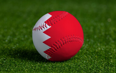 Baseball with Bahrain flag on green grass background, close up