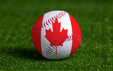 Baseball with Canada flag on green grass background, close up