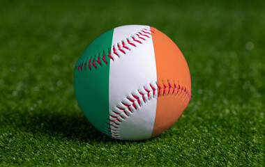 Baseball with Ireland flag on green grass background, close up