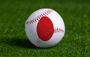 Baseball with Japan flag on green grass background, close up