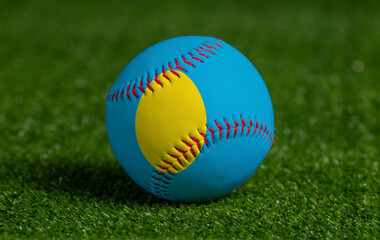 Baseball with Palau flag on green grass background, close up
