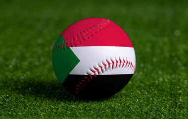 Baseball with Sudan flag on green grass background, close up