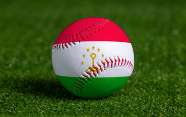 Baseball with Tajikistan flag on green grass background, close up