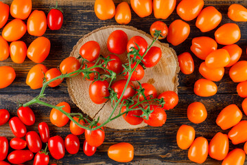 Fototapeta na wymiar Scattered tomatoes on wooden and cutting board background. flat lay.
