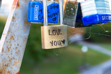 Locks with messages of love hanging from a bridge rail