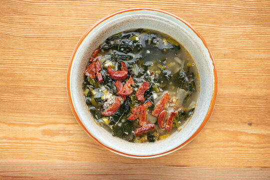 Portuguese cuisine soup with kale and chorizo sausage. Caldo verde soup.