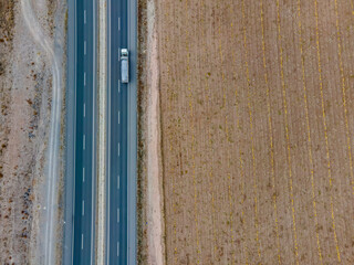Transport trucks on the highway passing by the cultivated field