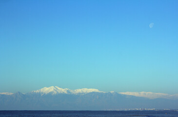 daytime view from the sea to the turkish mountainous landscape with the moon