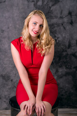 Naklejka premium Portrait of a cute fashionable woman in a red tight dress,