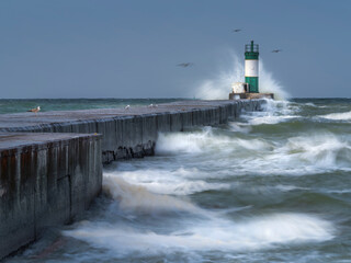 giant waves on lighthouse and pier in storm day
